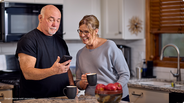 dean checking his glucose on his phone with his wife - smart devices sold separately